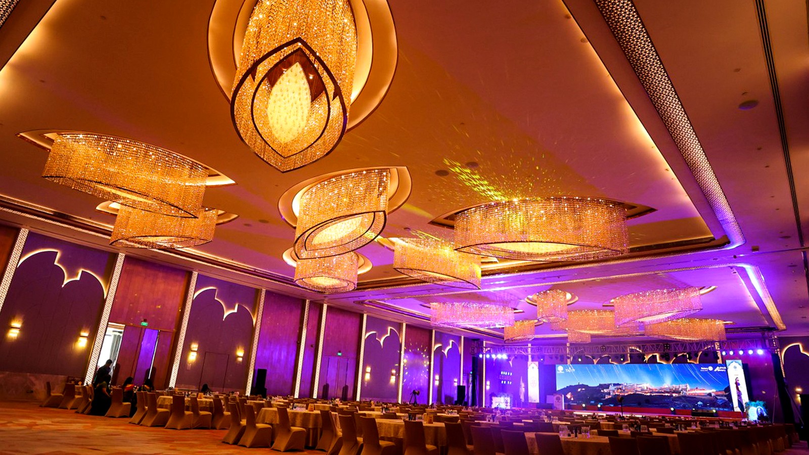 Corporate event ballroom with stage, projection lighting and banquet seating