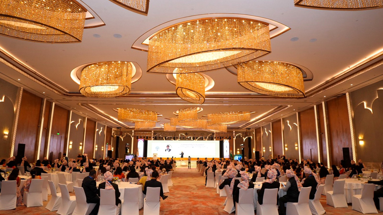 A live corporate conference with guests seated around the presentation stage