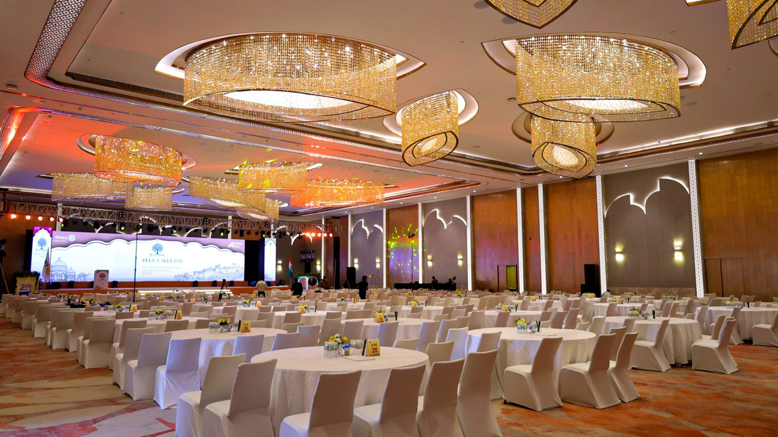 Corporate conference room prepared with round-table seating and a large presentation stage